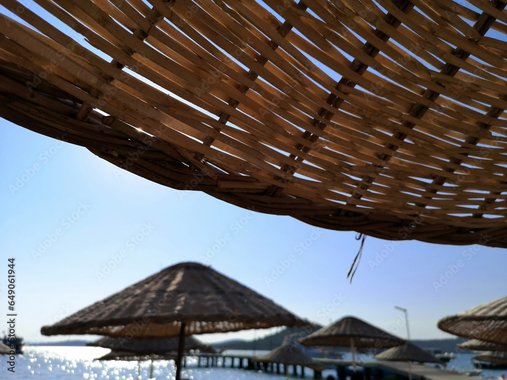 Φωτογραφία Große Sonnenschirme aus Korbgeflecht in Beige und Naturfarben im Sommer bei Sonn