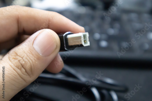 Connectivity in Hand: A Man Holding a Printer Cable
