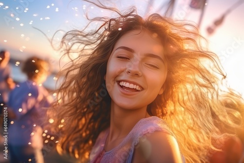Happy young woman with long curly hair on the beach at sunset. © Isabel
