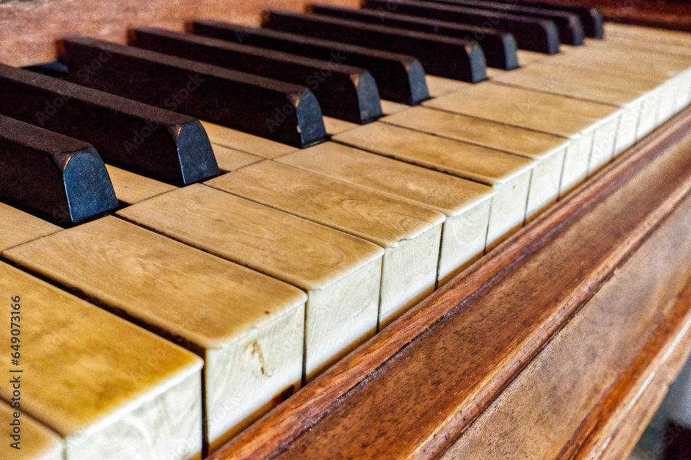 real elephant ivory piano keys on old wooden grand piano black and white keys with dirt, sweat and finger oils pattern detail late 1800s instrument, worn and well played top angled view real elephant ivory piano keys on old wooden grand piano black and white keys with dirt, sweat and finger oils pattern detail late 1800s instrument, worn and well played top angled view