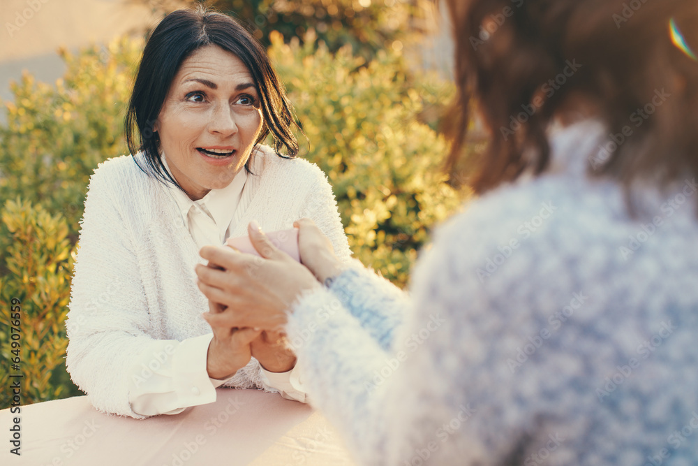 Two female friends laughing and hugging outdoors. Two female friends laughing and hugging outdoors.