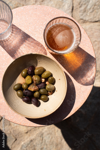 A beer and bowl of olives