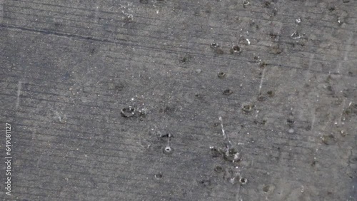 Heavy rain falls on the concrete floor.