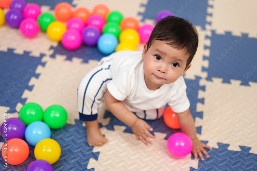 infant baby playing colorful balls in playpen infant baby playing colorful balls in playpen