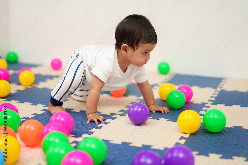 infant baby playing colorful balls in playpen infant baby playing colorful balls in playpen