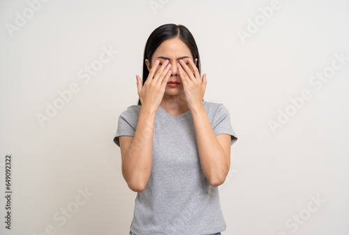 Young asian beautiful woman hand rubbing eyes she's feeling depressed stress headache be tired from working standing on isolated white background she has unwell unhealthy problems.