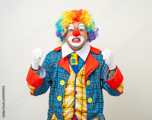 Mr Clown. Portrait of angry psycho mad comedian face Clown man in colorful uniform wearing wig looking camera. Upset stressed serious male bozo in various pose on isolated background.