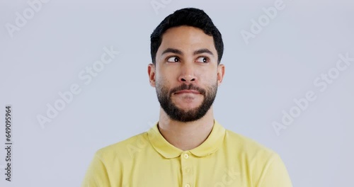 Face, guilty or awkward with a man in studio on gray background looking nervous or uneasy. Autism, doubt or adhd with an embarrassed young person thinking of an idea while feeling confused or unsure photo