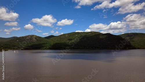 An aerial time lapse of the beautiful scenery from Donahue Memorial Park on a sunny day. The drone camera pan left and tilt down, viewing the mountains on the other side of the Hudson River and boats. photo