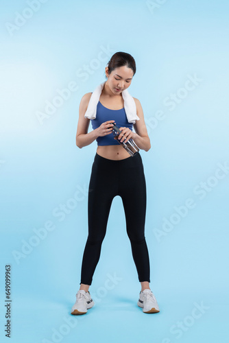 Fototapeta Naklejka Na Ścianę i Meble -  Athletic and sporty asian woman resting and drink water after intensive cardio workout training. Healthy exercising and fit body care lifestyle pursuit in studio shot isolated background. Vigorous