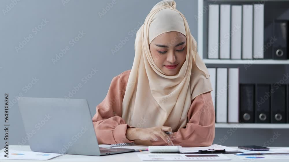 Motivated Muslim businesswoman wearing hijab working on real estate project analyzing document data graph discussing presentation work income calculation tax to a company in the office. Motivated Muslim businesswoman wearing hijab working on real estate project analyzing document data graph discussing presentation work income calculation tax to a company in the office.