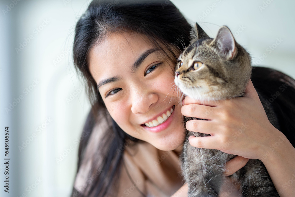 Young woman with cute cat resting at home. Pets and lifestyle concept.