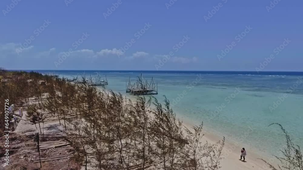 aerial view of beach with water and blue sky during the day on an island