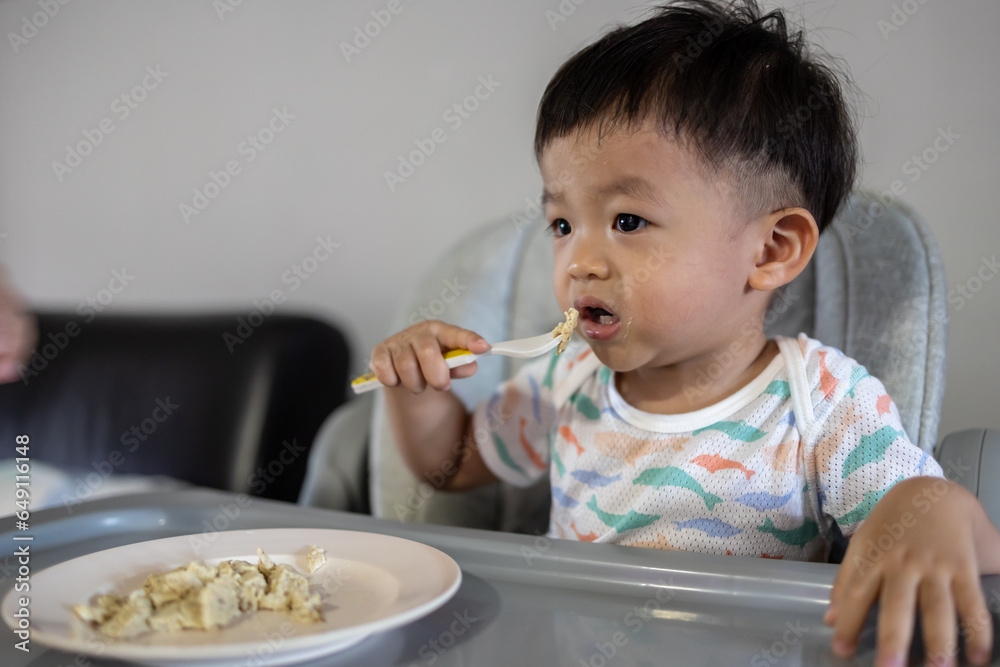 Happy 1-2 years old child enjoying his lunch Happy 1-2 years old child enjoying his lunch