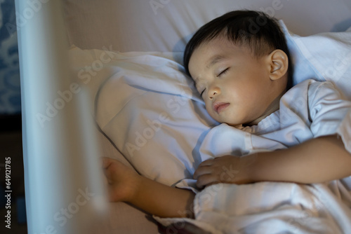 An Asian Chinese 1-2 yeas old kid lying on medical bed on bed rest after operation photo