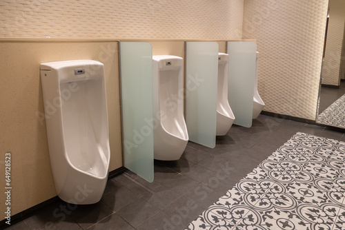 An image showcasing a sleek and contemporary men's public restroom. The design is characterized by clean lines, state-of-the-art fixtures, and a well-lit, inviting atmosphere