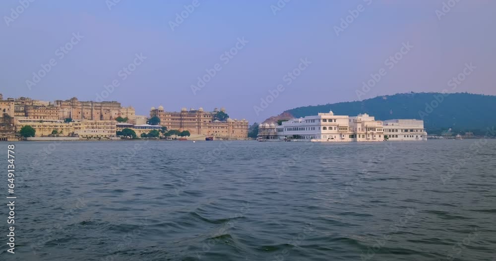 Udaipur City Palace view from moving boat on lake Pichola. Luxury palace is Rajput architecture of Mewar dynasty rulers of Rajasthan and famous tourist Indian landmark. Incredible India heritage Udaipur City Palace view from moving boat on lake Pichola. Luxury palace is Rajput architecture of Mewar dynasty rulers of Rajasthan and famous tourist Indian landmark. Incredible India heritage
