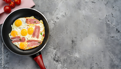 top view black frying pan with scrambled eggs and ham space around and concrete background