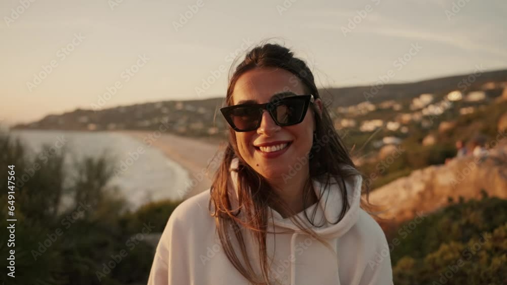 Front view of a young Spanish woman smiling at sunset with sea views Front view of a young Spanish woman smiling at sunset with sea views