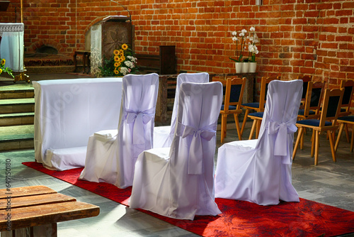 Kościół katolicki z widocznym ołtarzem i krzesłami dla pary młodej. ślub.  photo