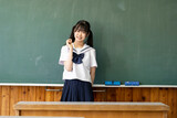 笑顔で黒板の前に立つ女子中学生