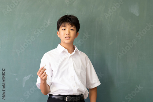 教室の黒板の前に立つ男子中学生