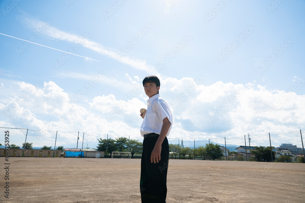 学校の校庭でボールを持つ男子中学生 学校の校庭でボールを持つ男子中学生