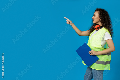 A girl in noise-absorbing headphones and a folder on a blue background