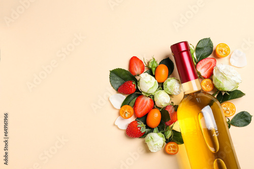 Glass bottle with wine, roses and fruits on beige background, space for text