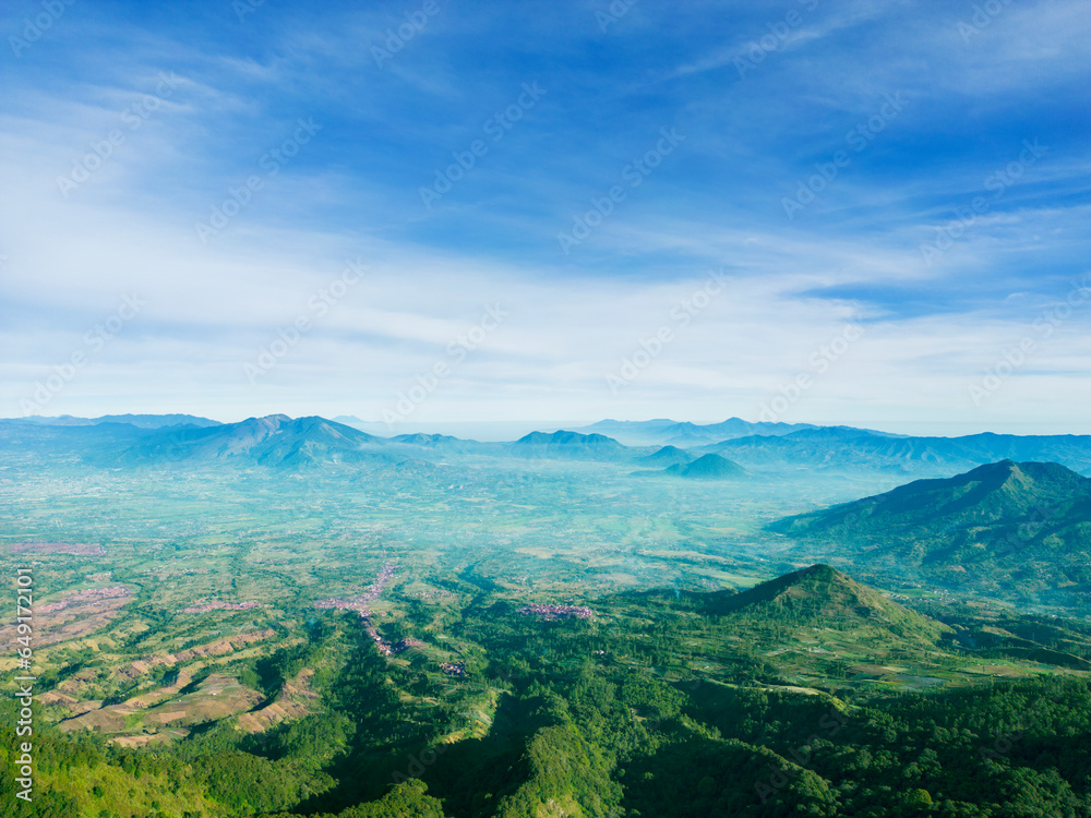 Aerial drone view of high mountains with thin fogs