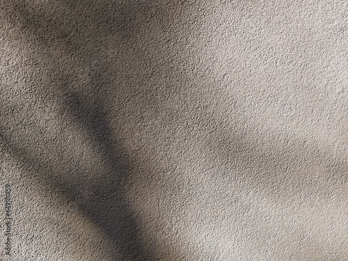 Plaster cement wall with deep shadows on it. Concrete grunge texture, abstract beige background.