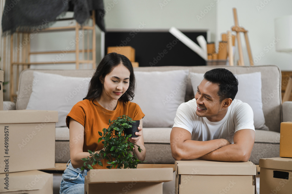 young couple helps put things in boxes and prepares, smiling happy moving to a new house. young couple helps put things in boxes and prepares, smiling happy moving to a new house.