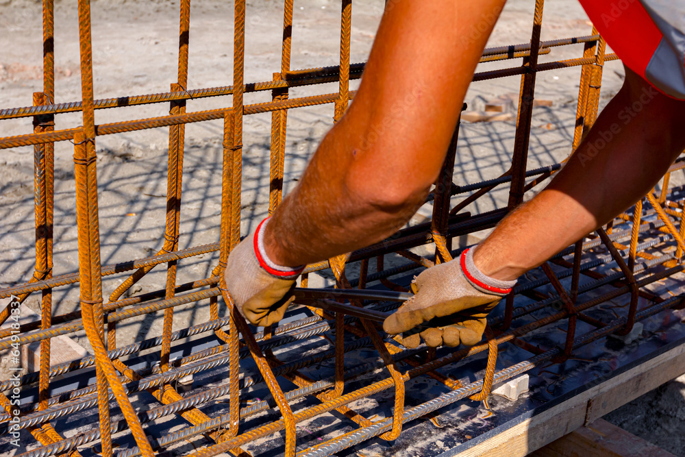 Construction worker binding rebar for reinforce concrete column at the building site.