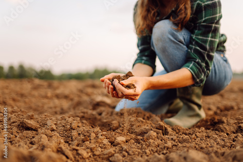 Close-up of female farmer's hands holding compost, fertile black soil to test the quality and health of the soil before sowing. Nature, gardening concept.