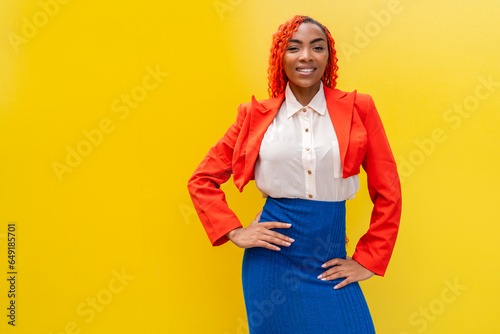 Smiling woman standing against yellow background photo
