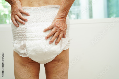 Asian senior woman patient wearing adult incontinence diaper pad in hospital.