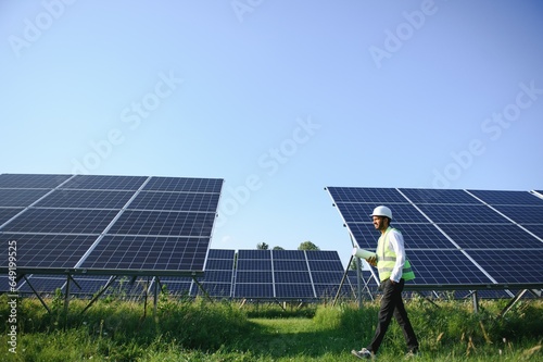 Portrait young indian technician or manager wearing formal cloths standing with solar panel. renewable energy  man standing crossed arm  copy space