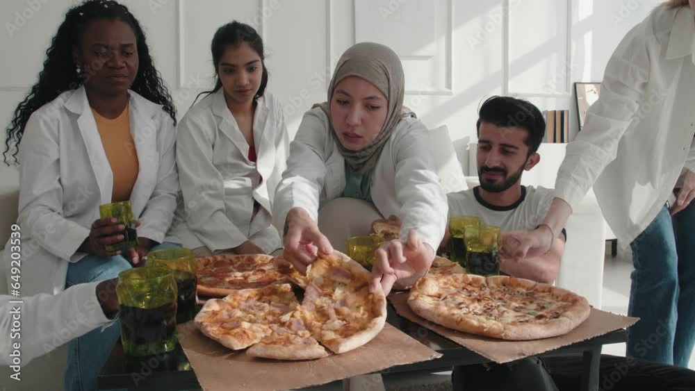 Happy excited medical staff workers eating lunch pizza during break, celebrating successful surgery, enjoying fast food at hospital clinic. Team building, healthy relationships at work, friendship Happy excited medical staff workers eating lunch pizza during break, celebrating successful surgery, enjoying fast food at hospital clinic. Team building, healthy relationships at work, friendship