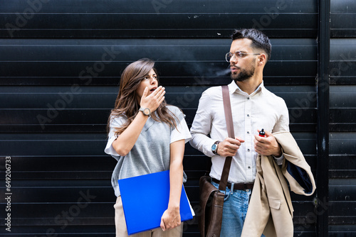 Εκτύπωση καμβά Young business woman is standing next to a colleague who is smoking a cigarette