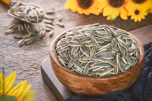 Organic unpeeled sunflower seeds in bowl. Close up with copy space.