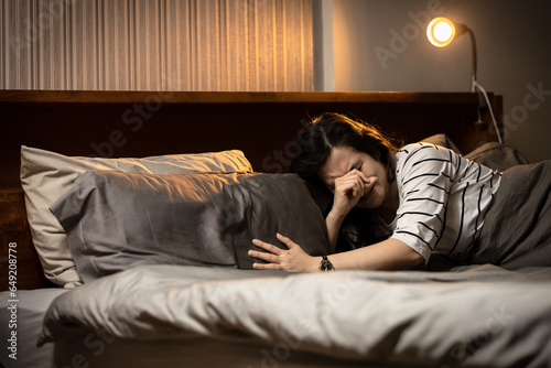 Middle aged woman crying in bed,experiencing grief and sorrow due to loss of husband,losing her family,dealing with the pain of loss,feeling a deep sense of sadness and despair,death of a loved one photo