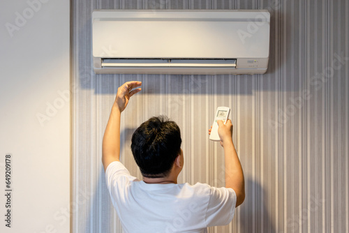 Asian man having a problem with air conditioner is not producing cold air,air conditioning only wind out,refrigerant leaking,dirt and clogging in air filter or malfunctions of the evaporator coil unit