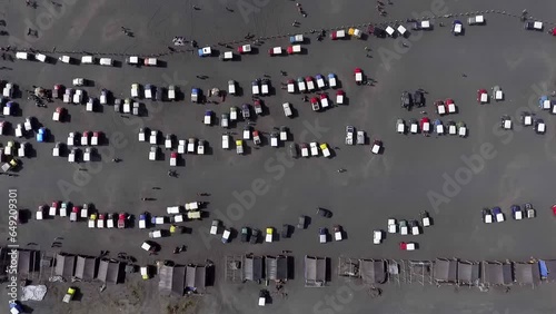 aerial view of hundreds of jeeps parked on a large sandy area at a tourist spot, in the morning, bromo, east java, indonesia photo