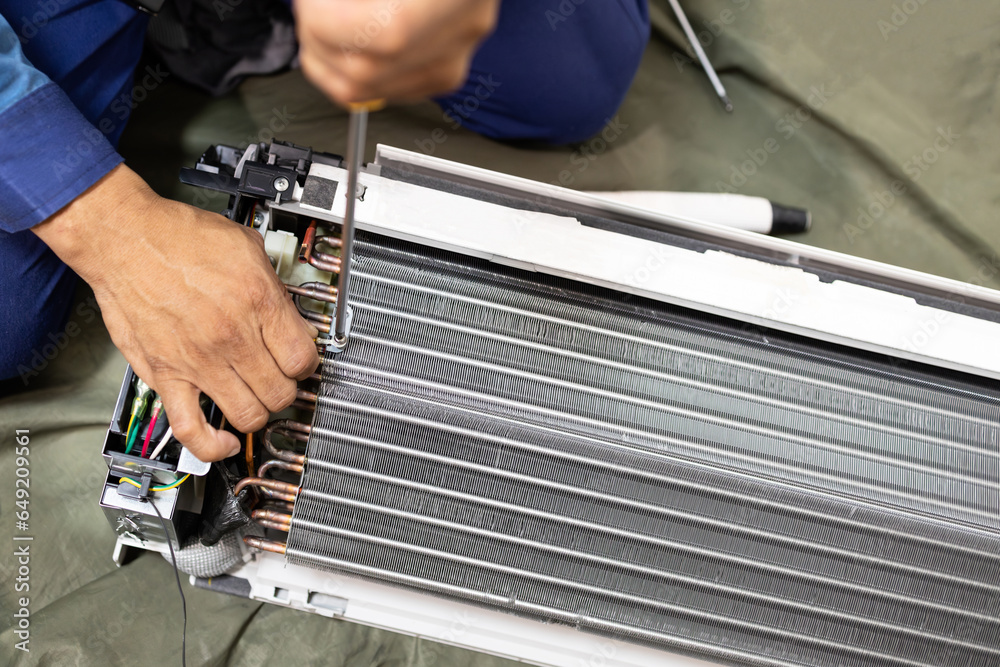 Technician is fixing or checking the evaporator system, troubleshooting air conditioning unit or dismantling for air conditioner fan coil unit cleaning,repair and maintenance,install air conditioner - obrazy, fototapety, plakaty 