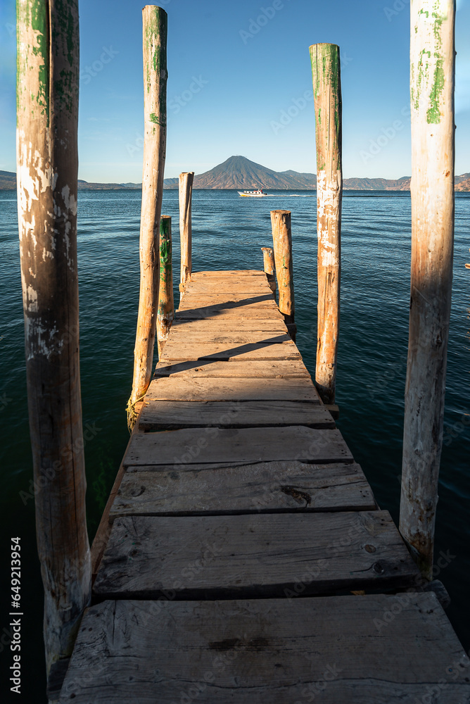 Wooden dock on Lake Atitlan on the beach in Panajachel, Guatemala. With Toliman and San Pedro volcanoes in the background Wooden dock on Lake Atitlan on the beach in Panajachel, Guatemala. With Toliman and San Pedro volcanoes in the background