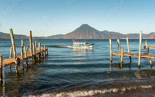 Wooden docks on Lake Atitlan on the beach in Panajachel, Guatemala. With Toliman and San Pedro volcanoes in the background