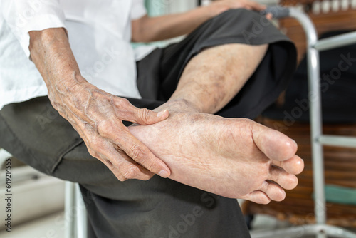 Elderly woman massage her foot,Plantar fasciitis,pain in soles of foot and heel bone,Tarsal tunnel syndrome,compression of a nerve in foot or Achilles tendonitis,inflammation of tendon at back of heel photo