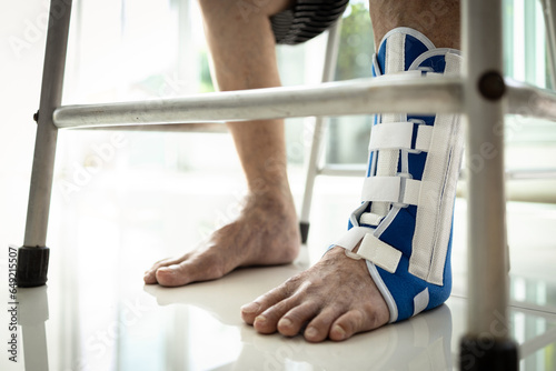 Leg of old elderly wearing foot support or ankle brace to protect the injured area,senior woman with chronic ankle instability,ankle sprains,problem of ligaments,treatment and rehabilitation concept photo