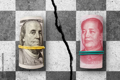 100 US dollars and 100 yuan banknotes on cracked concrete chess desk. Yuan is the currency of the China. Yuan and Dollar exchange rate. United States  and China trade war photo