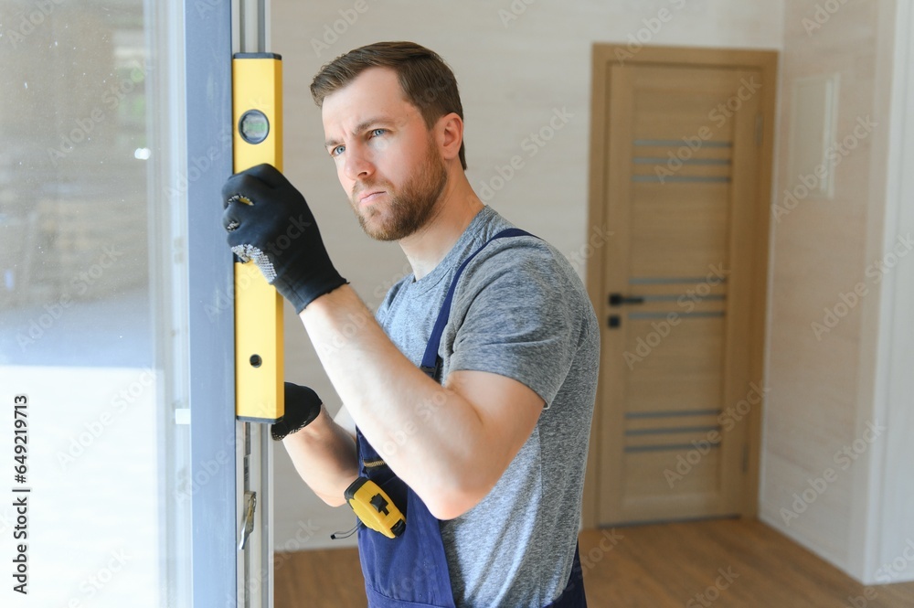 The worker installing and checking window in the house. Concept of new modular houses. The worker installing and checking window in the house. Concept of new modular houses.